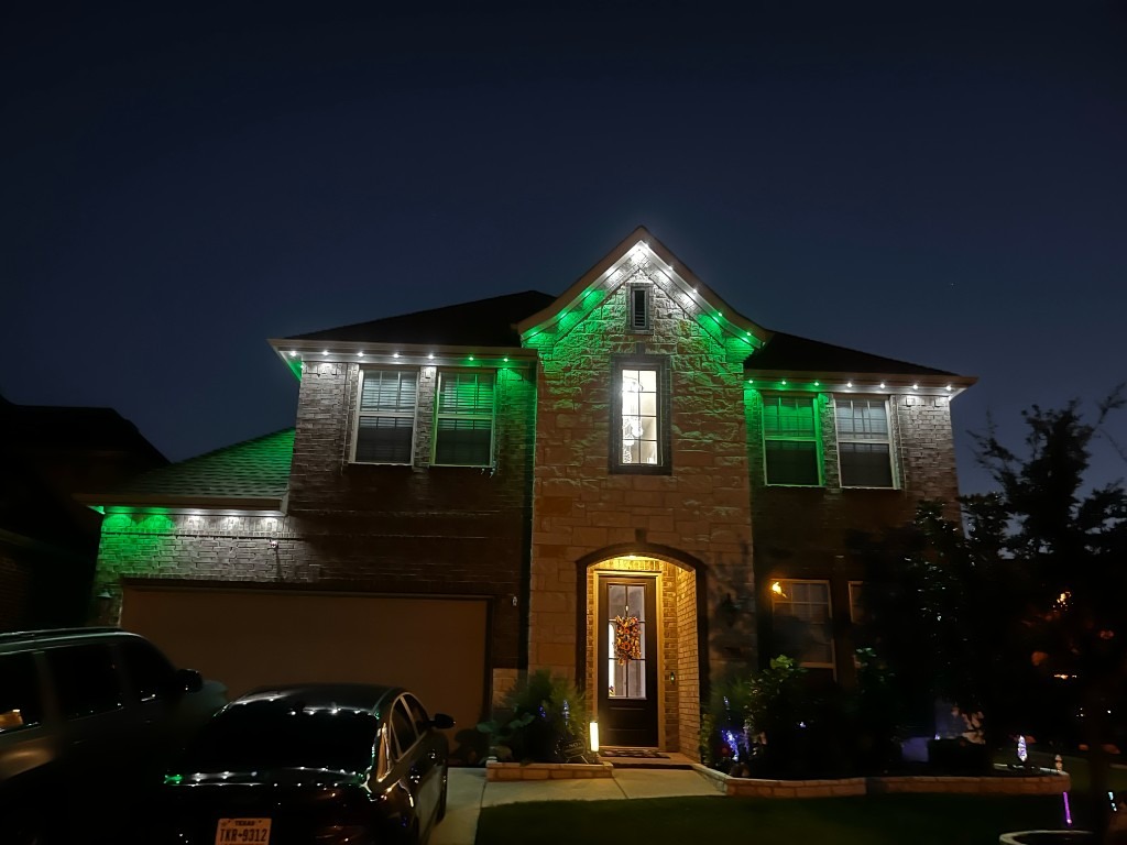 Roofline lit in green and white across peaks and eaves