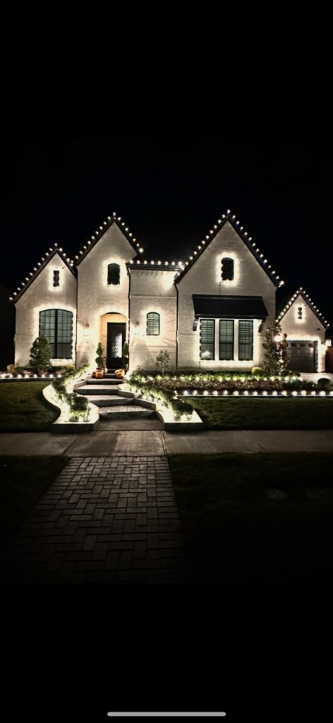 Warm white outline lighting on a brick home at night