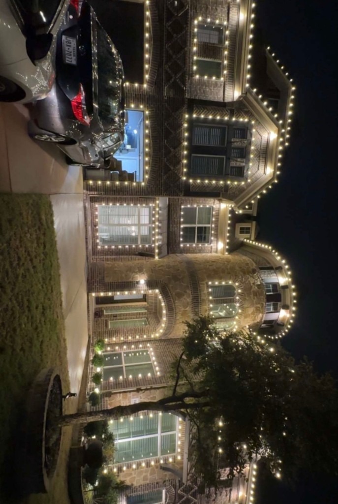 Full yard Christmas display with lit trees and snowflakes