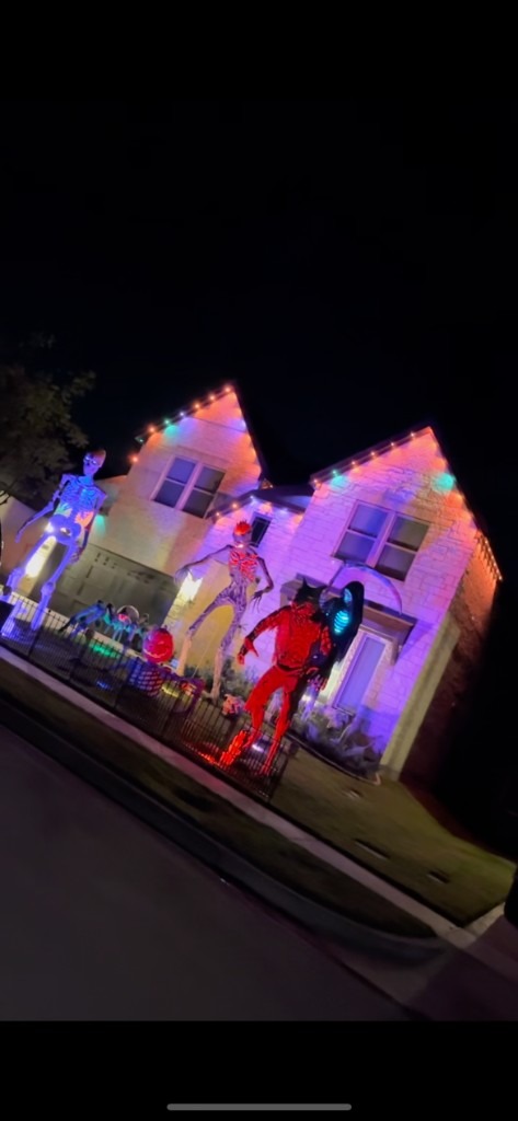 Colorful house wash lighting with a lit yard display