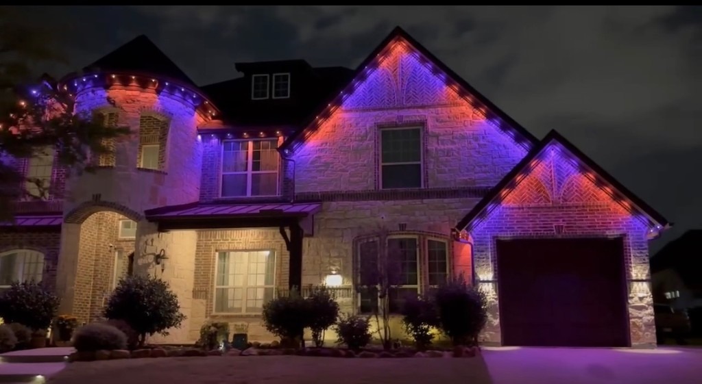 Warm white lights outlining rooflines, windows, and walkway
