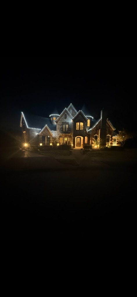 White roofline lighting on a large stone home